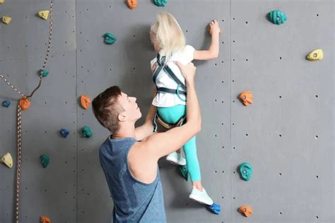 Instructors Helping Children Climb Wall In Gym — Stock Photo