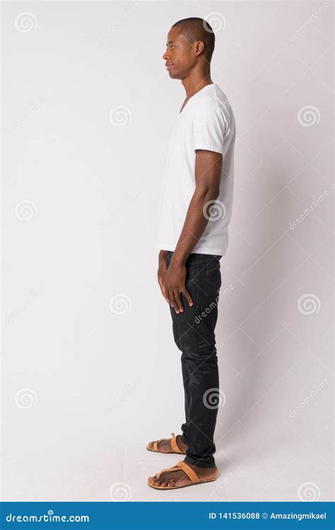 Full Body Shot Profile View Of Young Bald African Man Stock Photo