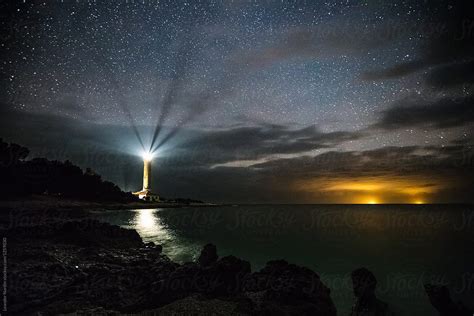 Illuminated Lighthouse Under Starry Night Sky Stocksy United
