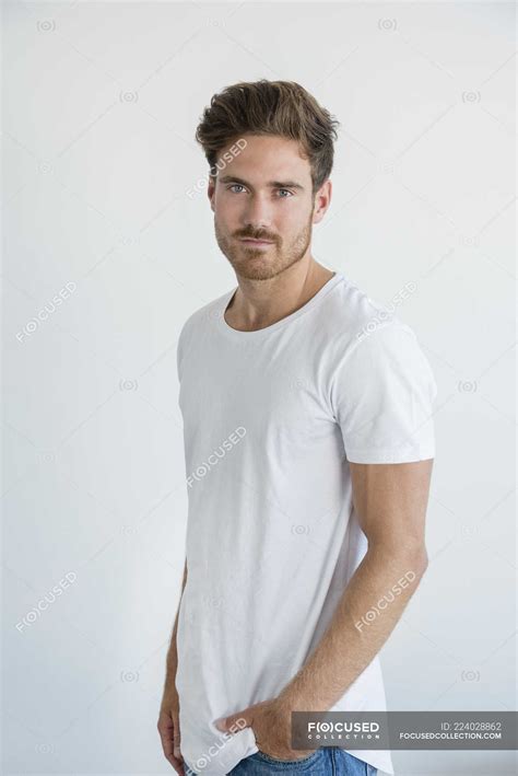 Portrait Of Handsome Young Man Posing In Front Of White Wall — Standing