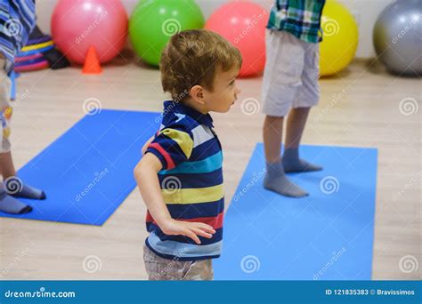 Cute Sporty Kid Exercising On Yoga Mats In Gym Children Sport School