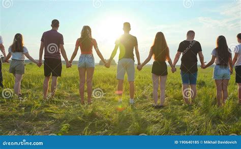 Cohesion Concept A Group Of Friends Are Holding Hands At Sunset Stock