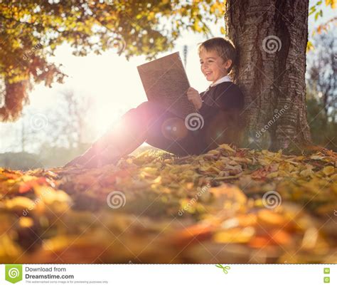 Wybierz z szerokiej gamy podobnych scen. Boy Sitting Under A Tree Reading Book Stock Image - Image ...