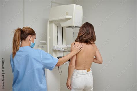 Female Medic In Masks And Uniform Preparing Woman With Naked Torso For Chest Radiology While