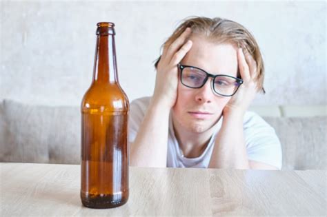 Premium Photo A Drunk Man With Glasses Suffers From A Hangover At Home