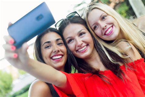 Tres Amigos Que Toman Las Fotos Con Un Smartphone En La Calle Imagen De Archivo Imagen De Foto