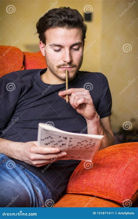 Young Man Sitting Doing A Crossword Puzzle Stock Image Image Of