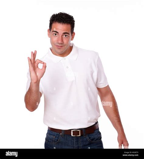 portrait of a handsome latin guy on white t shirt with ok gesture standing and looking at you on