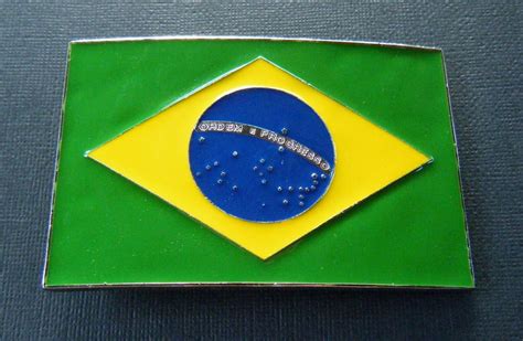 I romben er der en blå cirkel med hvide stjerner i fem forskellige størrelser samt et hvidt bånd, der løber gennem cirklen med blå streger. Brazil Brasil Brazilian Brasilien Rio Flag Belt Buckle