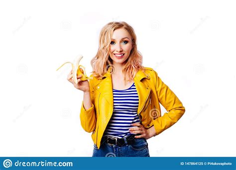Slim Blonde Girl With A Banana In Her Hands On An Isolated White