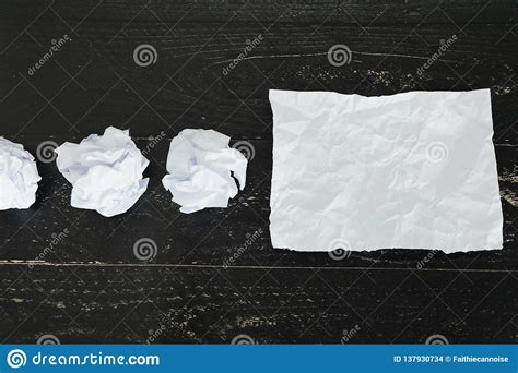 Set Of Scrunched Paper Balls And Empty Torn Sheet On Dark Moody