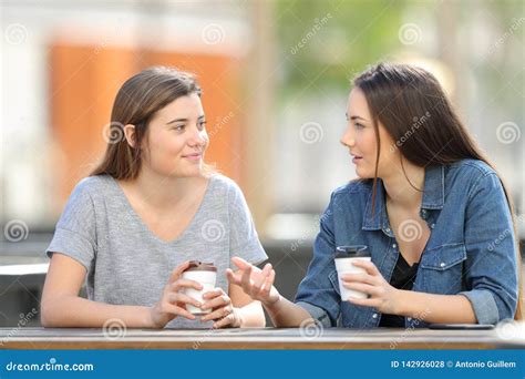 Two Friends Talking In A Park Drinking Coffee Stock Photo Image Of