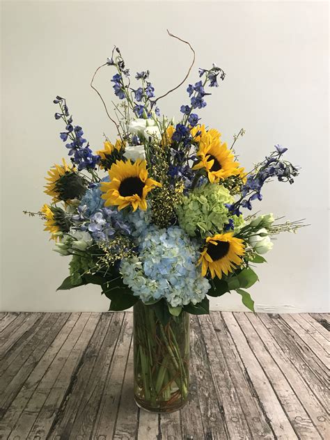 A Vase Filled With Blue And Yellow Flowers