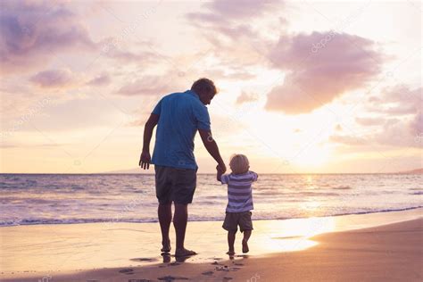Padre E Hijo Wallking En La Playa Fotografía De Stock © Epicstockmedia