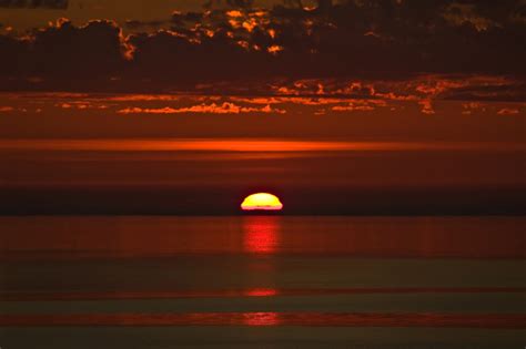 Photo Of A Red Sunset Where The Sun Disappears In The Ocean Photos