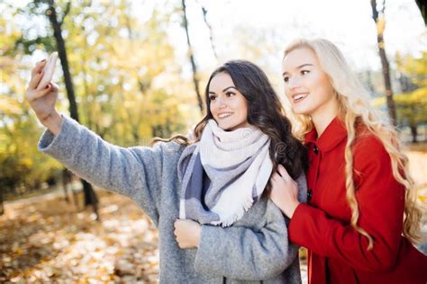 Two Beautiful Young Woman Taking Selfie In Autumn Day In Park Stock Image Image Of Happiness