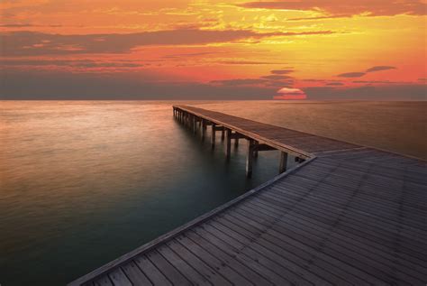 View Of The Sunset With Wooden Jetty By The Sea Phone Wallpapers