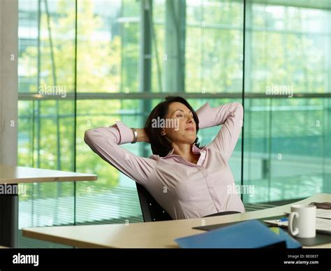 A Business Woman Leans Back In Her Chair Stock Photo Alamy