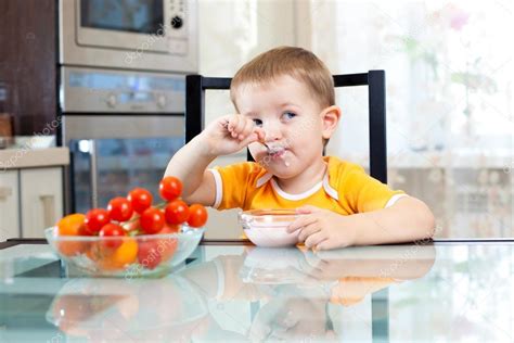 Child Boy Eating Healthy Food In Kitchen — Stock Photo © Oksun70 12891348