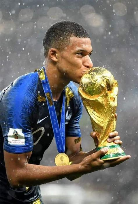 Soccer Player Kissing The World Cup Trophy With Rain Falling Down On Him And Holding It In His Hands