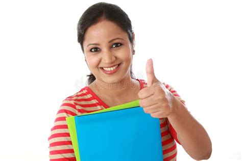 Happy Female Student Holding Text Book And Making Thumb Up Stock Photo