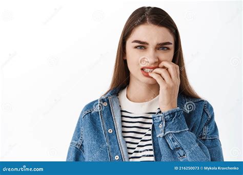 Nervous Girl Bites Her Finger Nails And Looks Worried At Camera