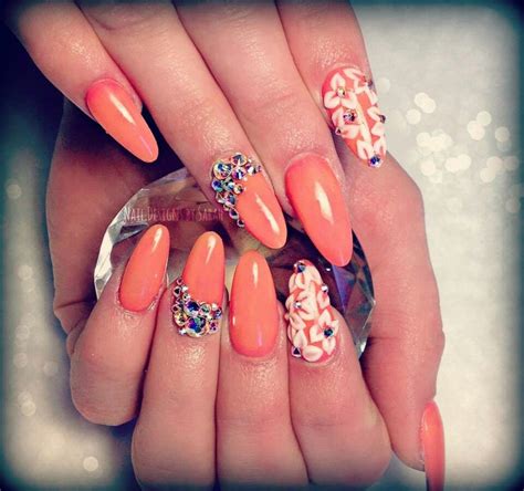 A Womans Hand With Orange And White Nail Polishes On Her Nails Which Are Decorated With