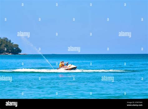 Сouple Man And Woman Enjoy Riding Hydrocycle In Blue Ocean Island On