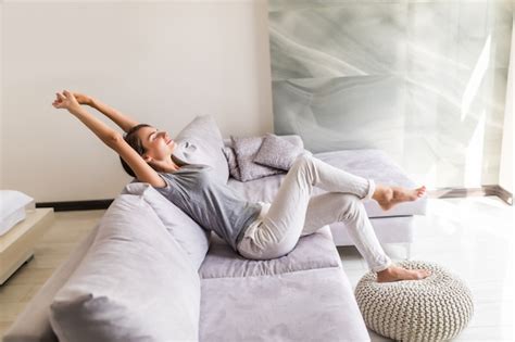 Free Photo Smiling Young Woman Relax Lying On Couch