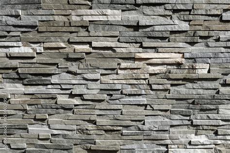 Stone Cladding Wall Made Of Striped Stacked Slabs Of Natural Gray And