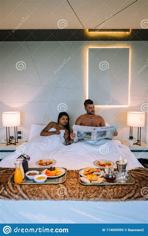 Couple Having Breakfast In Bed Men And Woman In Luxury Room And White