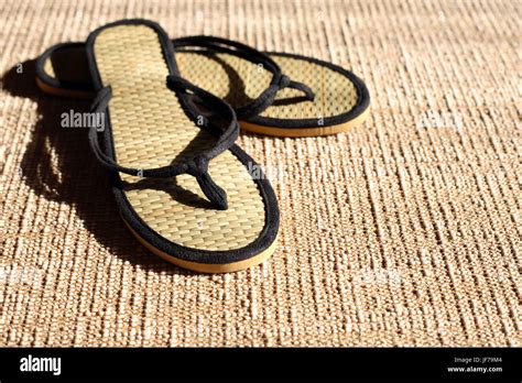 Pair Of Female Summer Thongs On Jute Surface Under Sunbeam Stock Photo