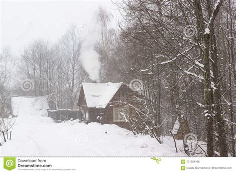 Smoke Comes From The Chimney Of A Rural House In A Snowy Forest Heavy
