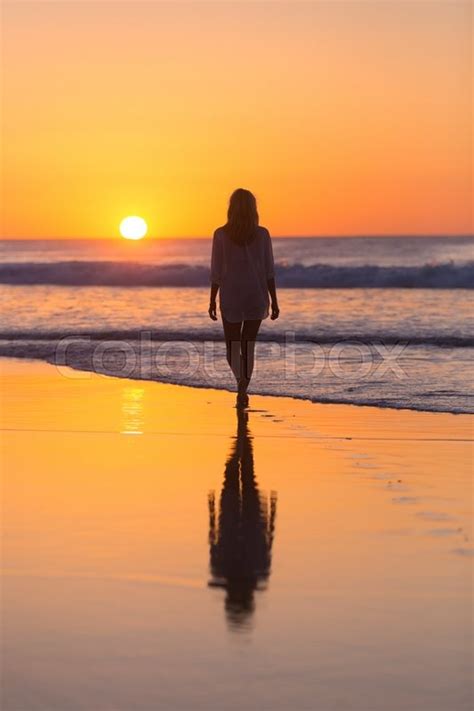Woman Walking On Sandy Beach In Sunset Stock Image Colourbox
