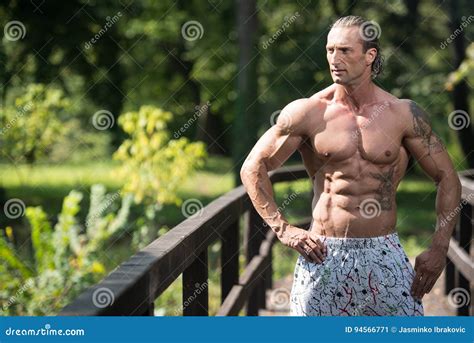 Bodybuilder Flexing Muscles Outdoors In Nature Stock Image Image Of