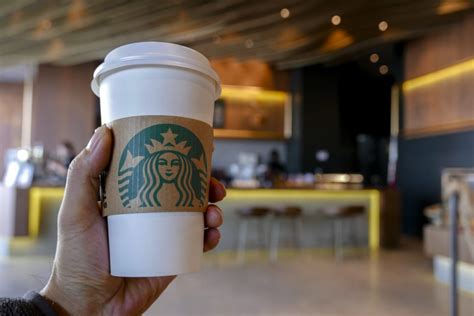 Hand Holding A Coffee Cup In A Starbucks Coffee Shop Since Pc Tech