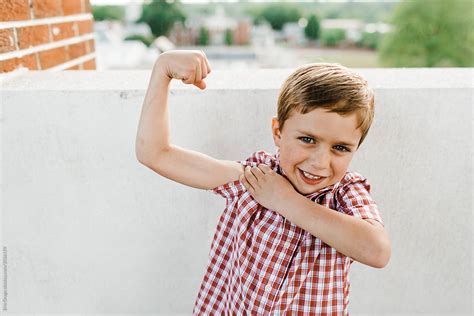Young Boy Flexing Muscles By Stocksy Contributor Erin Drago Stocksy