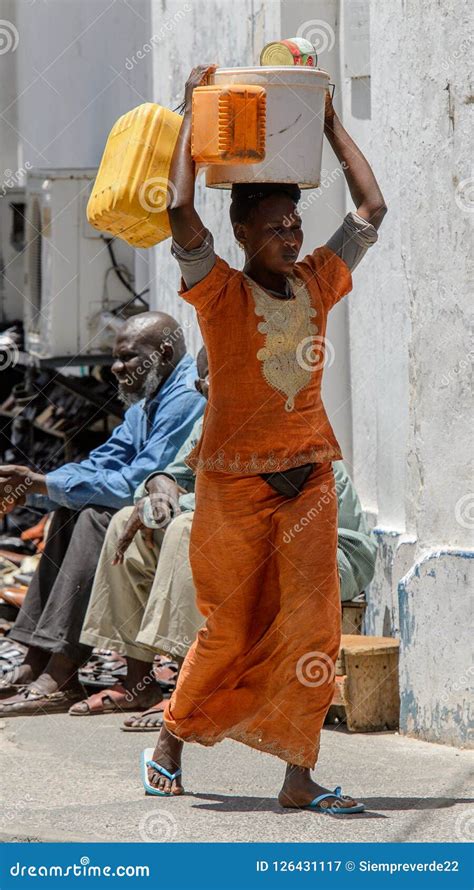 unidentified senegalese woman carries a bucket on her head in t editorial photography image of