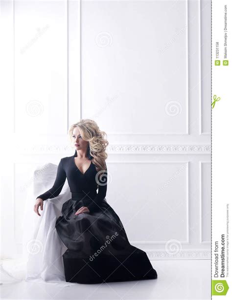 Beautiful Blond Woman Posing In A Black Dress Girl Sitting On Armchair