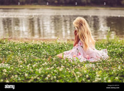 Sad Lonely Girl With Long Blond Hair In Pink Dress Sitting Alone As