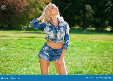 Beautiful Blonde Woman Dressed In A Denim Jacket And Shorts Stock Photo Image Of Outdoors