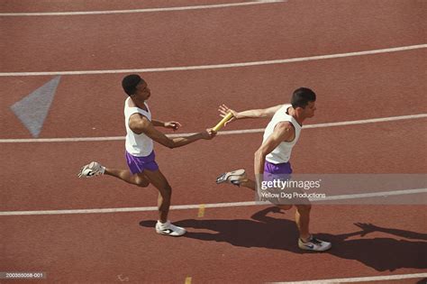 Male Runner Passing Baton In Relay Race Elevated View High