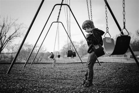 Black And White Photo Of Kids On Park Swings By Mel