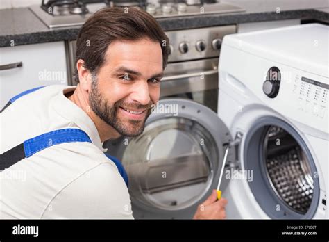 Handyman Fixing A Washing Machine Stock Photo Alamy