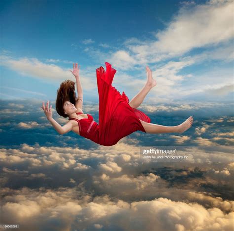 Mixed Race Woman Falling Through Clouds High-Res Stock Photo - Getty Images