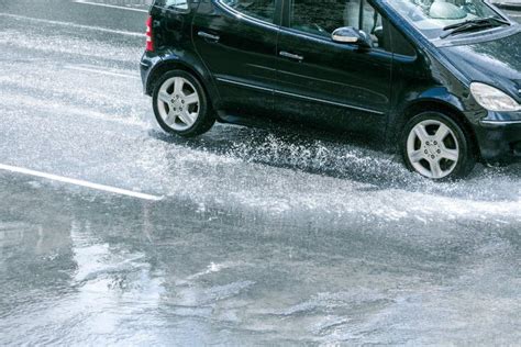 Car Driving On Flooded Road After Rain With Water Splashes Stock Image