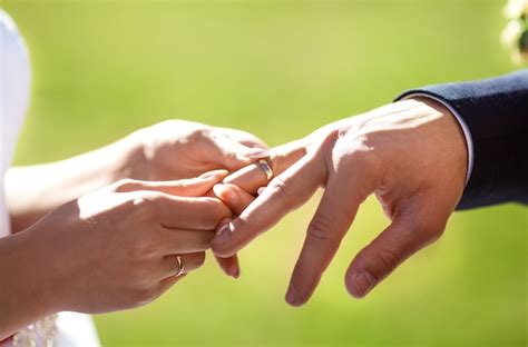 Marié Met Une Bague Sur Le Doigt De La Mariée Debout Devant Le Prêtre Photo Premium