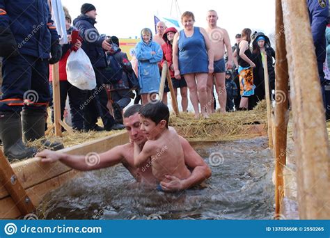 Il Battesimo Ortodosso Di Festa In Russia Una Folla Della Gente Nuda Si Tuffa Nell Acqua