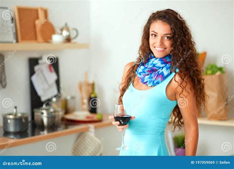 Mujer Guapa Tomando Algo De Vino En La Cocina Imagen De Archivo