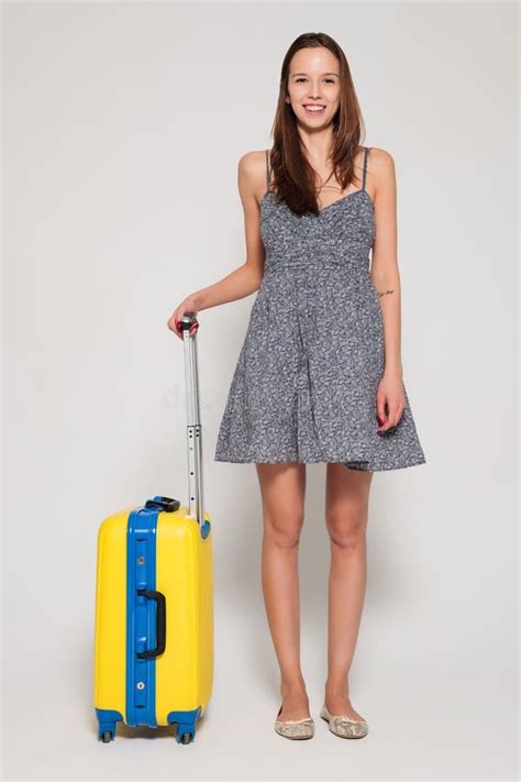 Beautiful Girl With A Yellow Suitcase Loves To Travel Stock Photo
